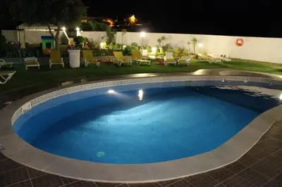 a large swimming pool in a yard at night at Sunshine in Albufeira