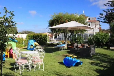 a yard with a table and chairs and an umbrella at Sunshine in Albufeira