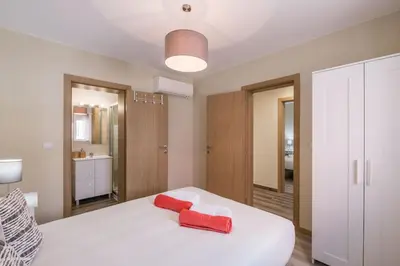 a bedroom with a white bed with two red towels on it at LovelyStay - Sweet Escape I - Terrace in Quarteira