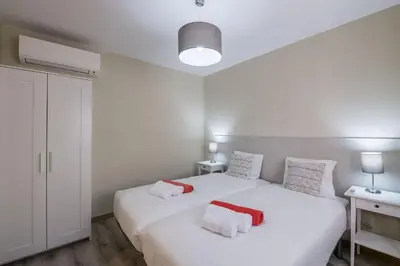 a bedroom with a white bed with red and white towels at LovelyStay - Sweet Escape I - Terrace in Quarteira