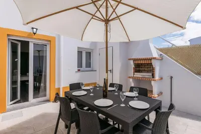 a dining table with an umbrella on a patio at LovelyStay - Sweet Escape I - Terrace in Quarteira