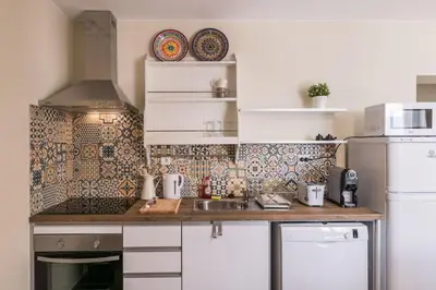 a kitchen with white cabinets and a sink and a refrigerator at LovelyStay - Sweet Escape I - Terrace in Quarteira