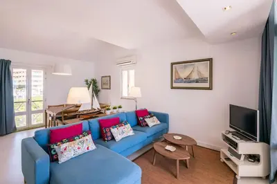 a living room with a blue couch and a tv at LovelyStay - Two Bedroom Duplex at Vilamoura Marina in Vilamoura