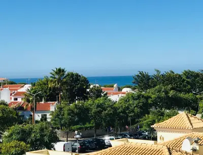a view of a city with trees and the ocean at SOMAR Torre de Medronheira OLHOS DE AGUA ALBUFEIRA in Olhos de Água