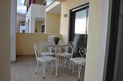 a balcony with a table and chairs and a window at SOMAR Torre de Medronheira OLHOS DE AGUA ALBUFEIRA in Olhos de Água