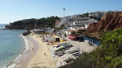 a beach with chairs and umbrellas and the ocean at SOMAR Torre de Medronheira OLHOS DE AGUA ALBUFEIRA in Olhos de Água