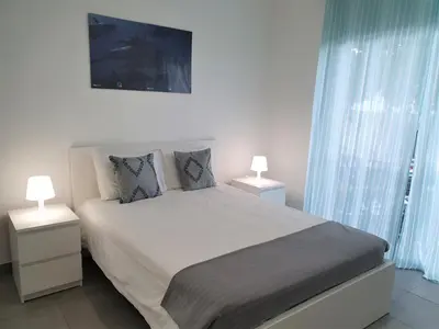 a bedroom with a large bed with two night stands at Lote 1 Aconchegante in Quarteira