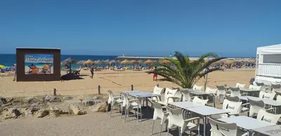 a group of tables and chairs on a beach at T2 Gaveto- Frente Mar, Wifi, Aconchegante & Familiar in Quarteira