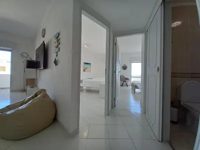a white room with a couch and a bedroom at T2 Gaveto- Frente Mar, Wifi, Aconchegante & Familiar in Quarteira