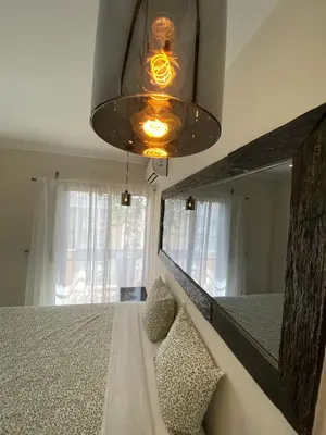 a bedroom with a bed with a mirror and a chandelier at AL MMaria in Faro
