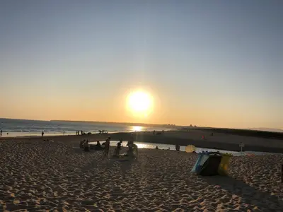 a group of people on a beach at sunset at Dream House - Condominio com piscina aquecida e propriedade com 5 bicicletas incluindo 1 eletrica in Albufeira