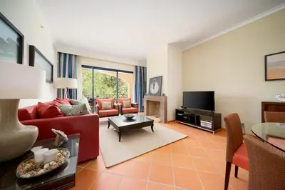 a living room with a red couch and a tv at AL - Apartamento Vila Sol F5 AH in Quarteira