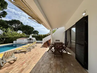 a backyard with a pool and a table and umbrella at Vilamoura Ocean Villa with Pool by Homing in Vilamoura