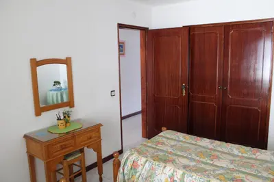 a bedroom with a bed and a mirror and a table at Naturmar Praia in Albufeira