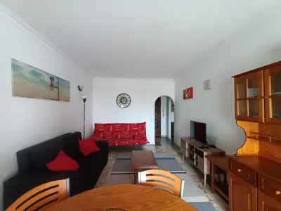 a living room with a red couch and a table at Oura Li in Albufeira