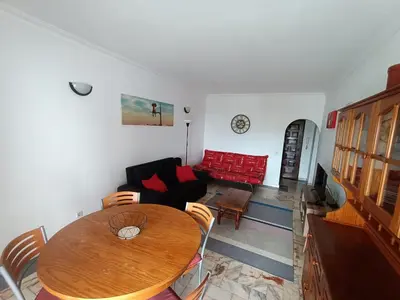 a living room with a table and a red couch at Oura Li in Albufeira