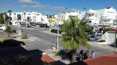 a city street with a palm tree and buildings at Oura Li in Albufeira