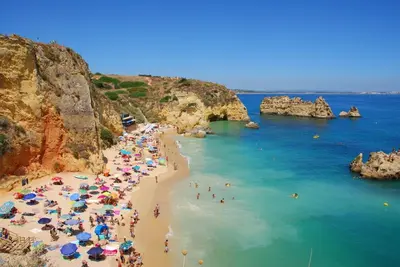 a group of people on a beach with umbrellas at Cozy apartment in Albufeira 76 m² with lovely terrace in Albufeira