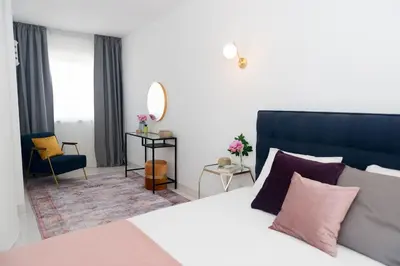 a bedroom with a large bed and a mirror at Casa Olga Vieira in Albufeira