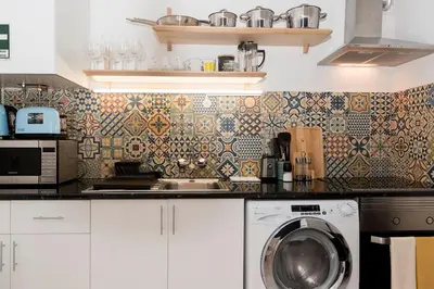 a kitchen with a sink and a washing machine at Casa Olga Vieira in Albufeira