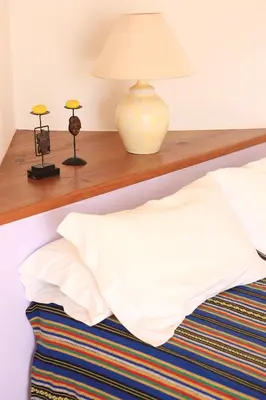 a bed with a wooden shelf with a lamp on it at Monte das Cortelhas in Guia
