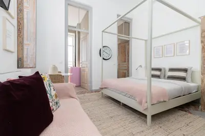 a bedroom with a canopy bed and a couch at aleixomor'Aqui in Loulé