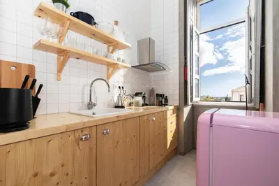 a kitchen with wooden cabinets and a pink refrigerator at aleixomor'Aqui in Loulé