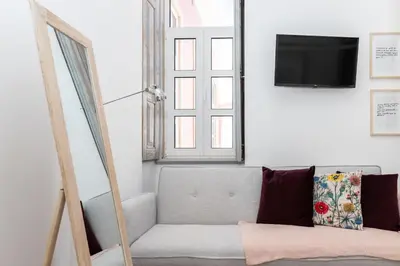 a living room with a couch and a tv at aleixomor'Aqui in Loulé
