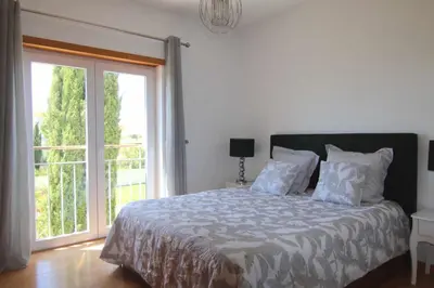 a bedroom with a bed and a large window at Golf Mar Village By Vilamoura Sun- Vista Golfe in Vilamoura