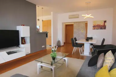 a living room with a couch and a tv and a table at Golf Mar Village By Vilamoura Sun- Vista Golfe in Vilamoura