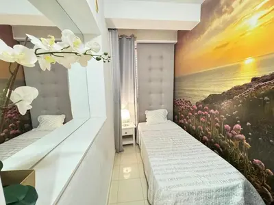 a room with two beds and a painting of flowers at Golf Mar Village By Vilamoura Sun- Vista Golfe in Vilamoura