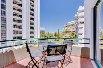 two chairs and a table on a balcony with buildings at Algamar Apartment - Vilamoura Center in Vilamoura