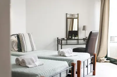 a bedroom with two beds and a chair and a mirror at Algamar Apartment - Vilamoura Center in Vilamoura