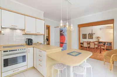 a kitchen with a table and a dining room at Apartamento dentro da Marina de Vilamoura in Vilamoura