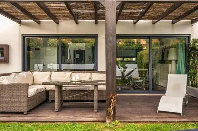 a patio with a couch and a table on a deck at Townhouse 3 Bedroom Townhouse Olhos de Agua Communal pool AT03 in Olhos de Água