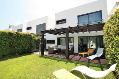 a backyard with chairs and a pergola at Townhouse 3 Bedroom Townhouse Olhos de Agua Communal pool AT03 in Olhos de Água