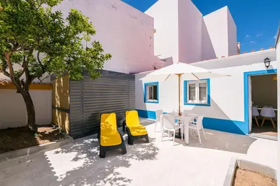 a patio with two yellow chairs and a table at LovelyStay - Sweet Escape II - Backyard in Quarteira