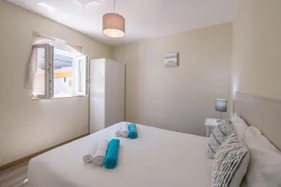 a bedroom with a white bed with blue shoes on it at LovelyStay - Sweet Escape II - Backyard in Quarteira