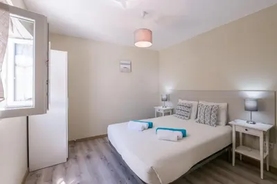 a bedroom with a large white bed and a window at LovelyStay - Sweet Escape II - Backyard in Quarteira