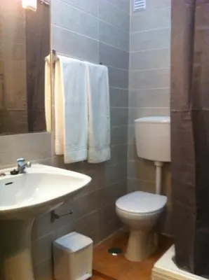 a bathroom with a white toilet and a sink at Rossio in Albufeira