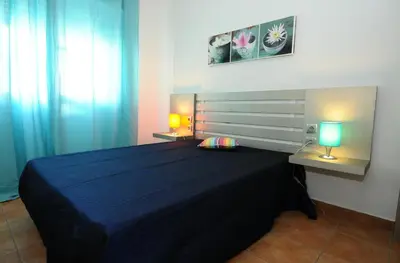 a bedroom with a bed and two lamps on tables at Rossio in Albufeira