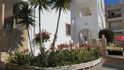 a garden in front of a building with palm trees at Apartamento - 2 a 4 Pessoas- Piscina in Olhos de Água