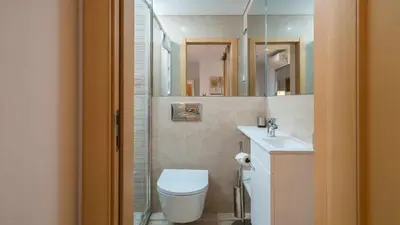 a bathroom with a toilet and a sink and mirror at Marina Vilamoura Aquamar 203 By Vilamoura Sun in Quarteira