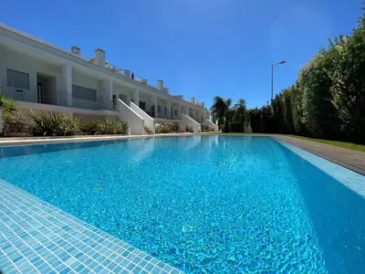 a large blue swimming pool next to a building at Albufeira Lux Apartment in Albufeira