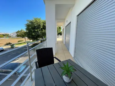 a patio with a table and chairs on a roof at Albufeira Lux Apartment in Albufeira
