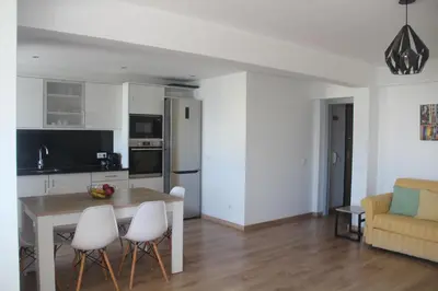 a kitchen and living room with a table and chairs at Casa do Largo in Faro