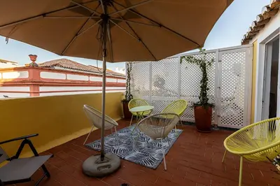 a patio with chairs and a table and an umbrella at Faro Guest House in Faro