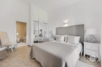 a living room with chairs and a table and windows at Casa Julia - Dunas Douradas in Faro