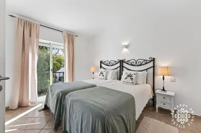 a white bedroom with a bed and a toilet at Casa Julia - Dunas Douradas in Faro