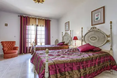 a bedroom with two beds and a chair at Villa Antao in Guia